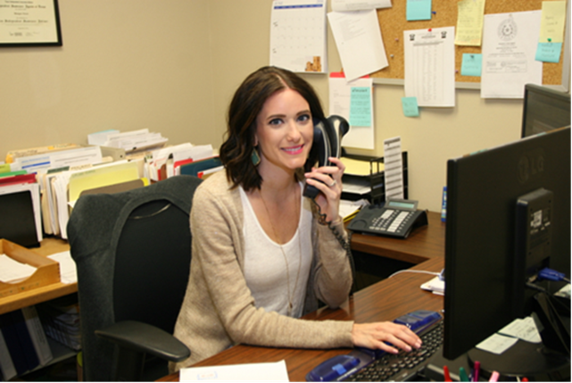 a woman sitting at a desk in front of a computer